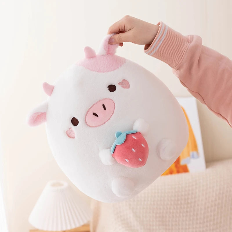 Cute kawaii plush toy resembling a cow with a strawberry on a light background