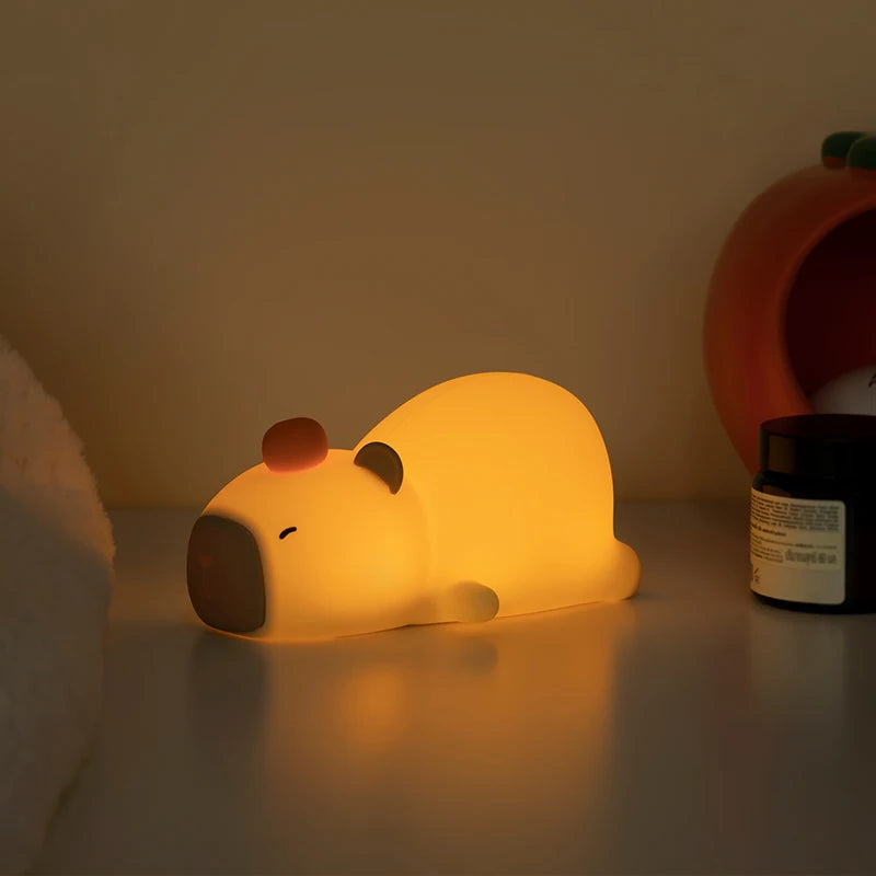 Yellow kawaii bear-shaped night light on a surface with a blurred background