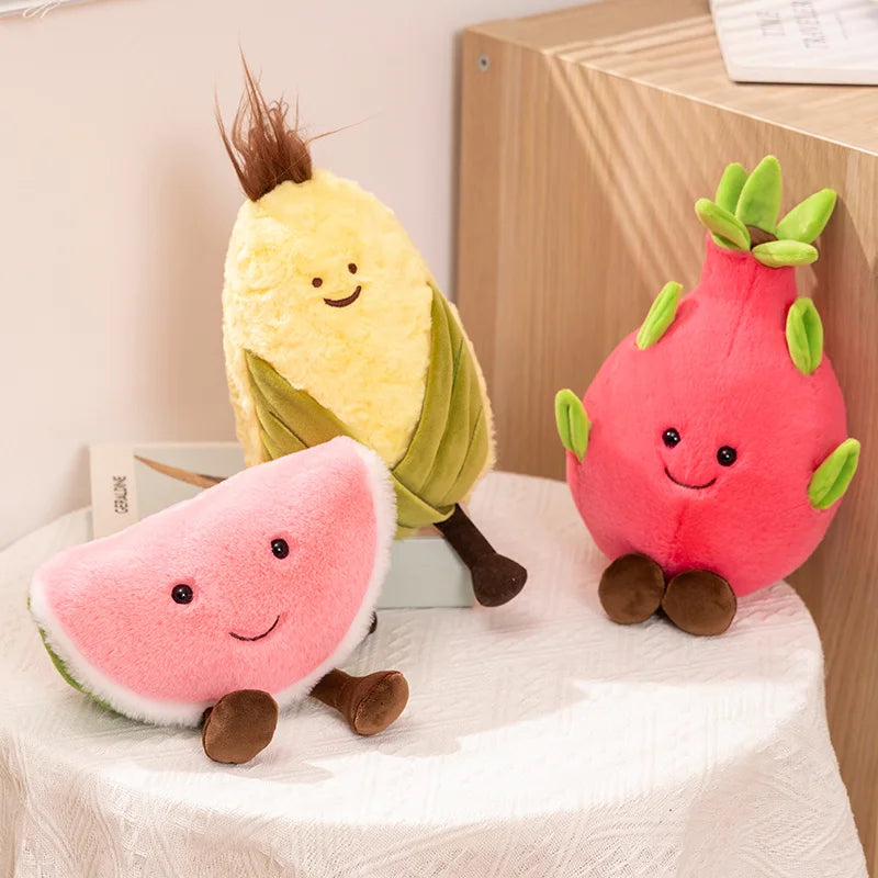 Three plush kawaii toys shaped like a watermelon, banana, and dragon fruit on a white surface.