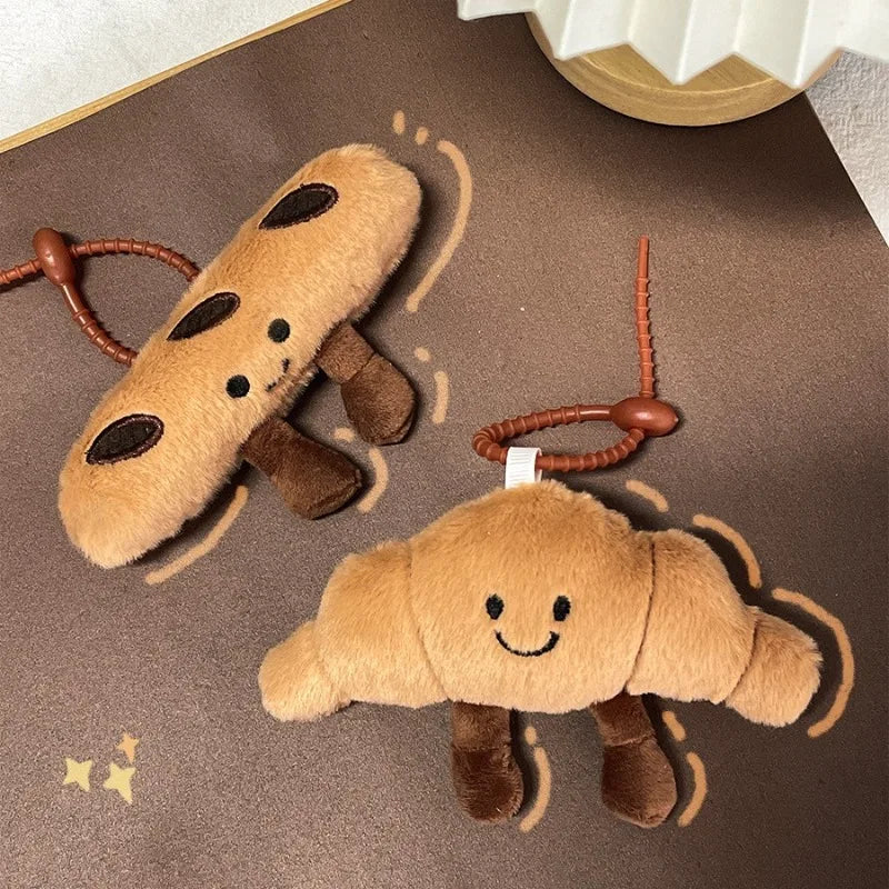 Two kawaii plush toy keychains shaped like cartoon moles on a brown surface.