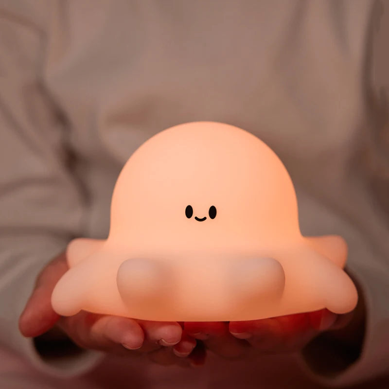 Cute, glowing octopus-shaped kawaii night light held in hands against a neutral background