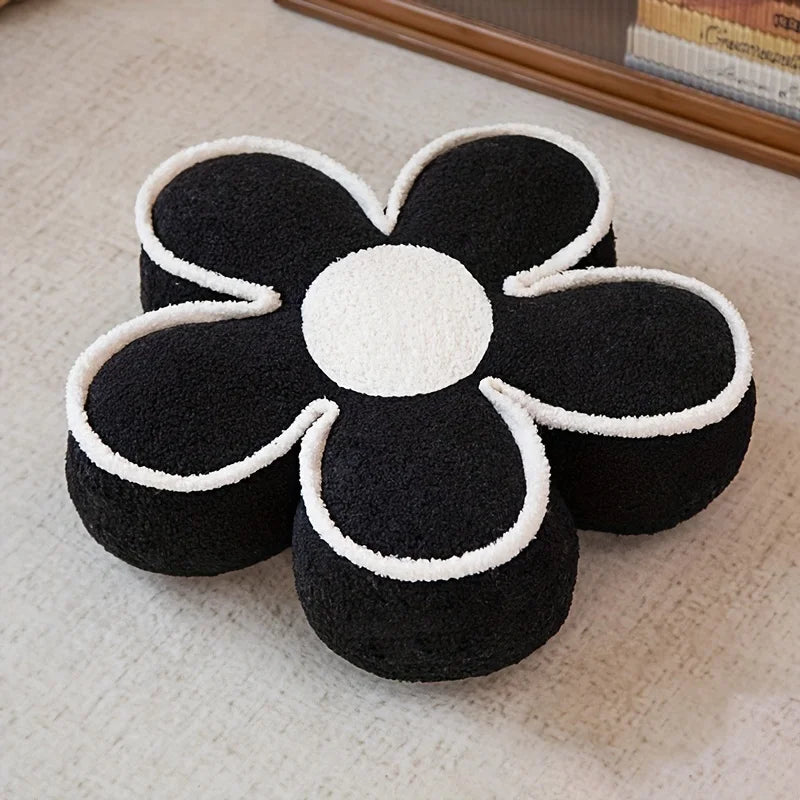 Black and white flower-shaped kawaii cushion on a beige carpet