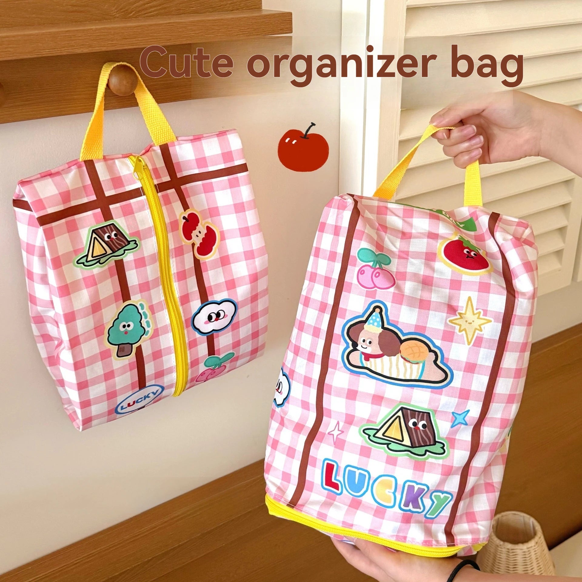 Pink checkered organizer bag with Kawaii cartoon designs and 'LUCKY' text, held by a hand.