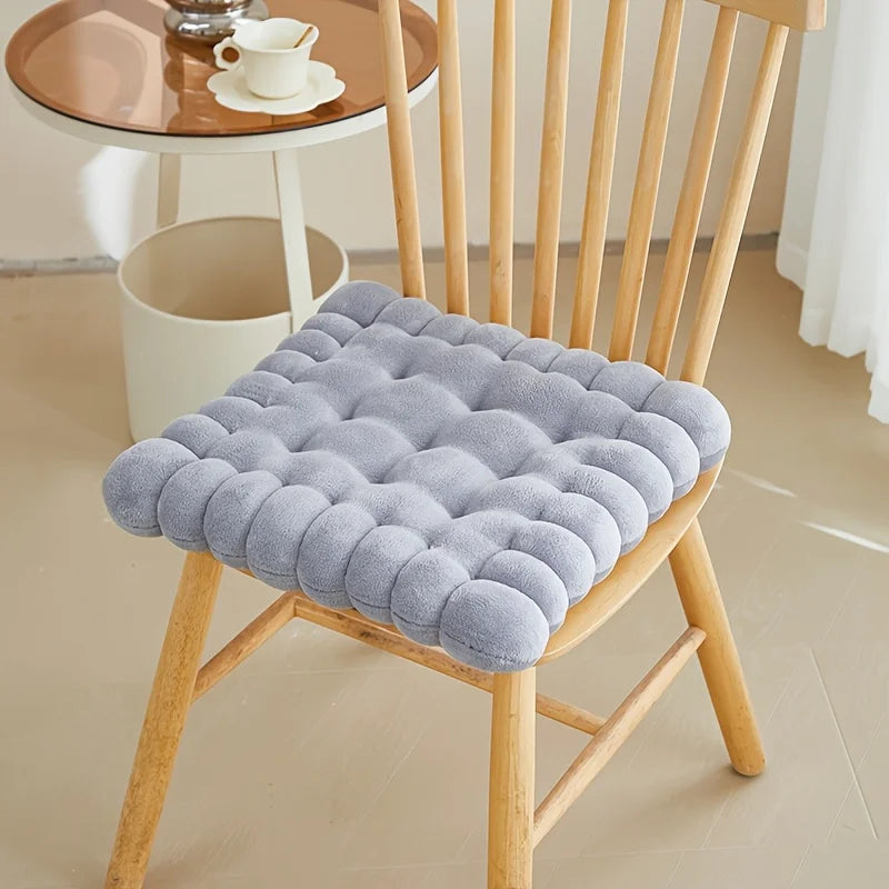 Gray kawaii cushion on a wooden chair in a room setting