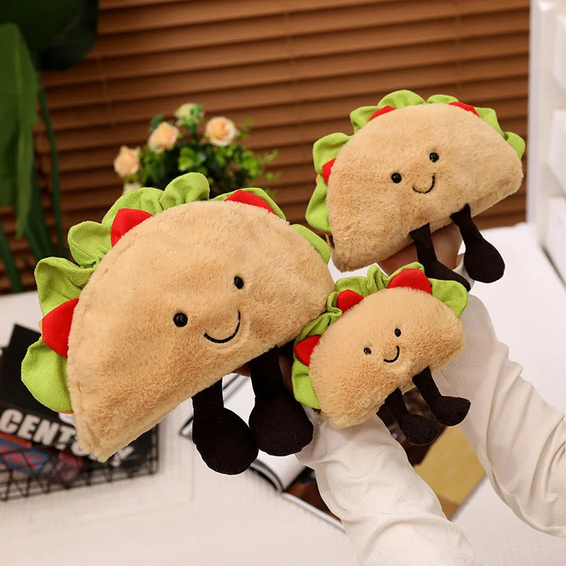 Three kawaii plush taco toys with smiling faces on a blurred indoor background