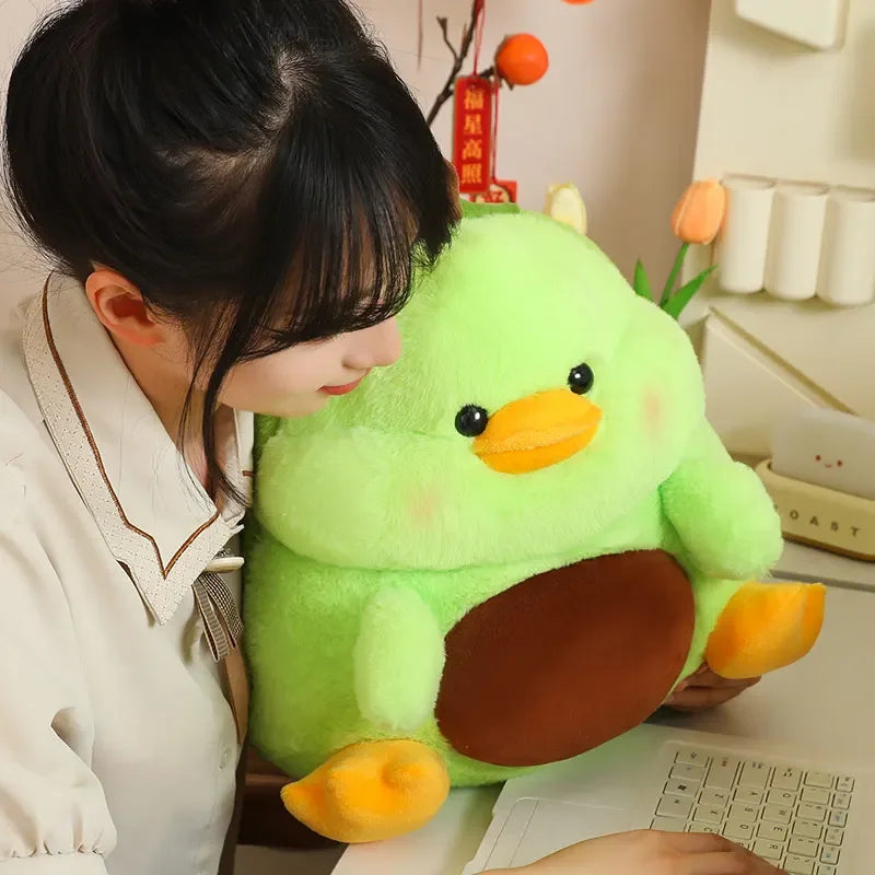 Person holding a large green kawaii plush toy at a desk with a laptop.