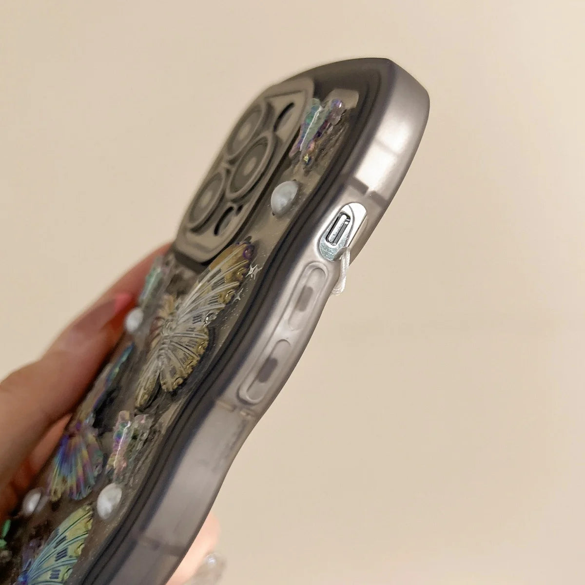 Kawaii phone case with decorative elements held by a hand on a beige background