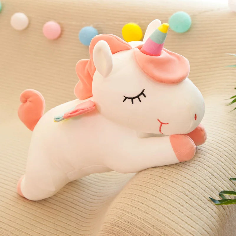 Plush unicorn kawaii toy with a rainbow horn on a beige surface