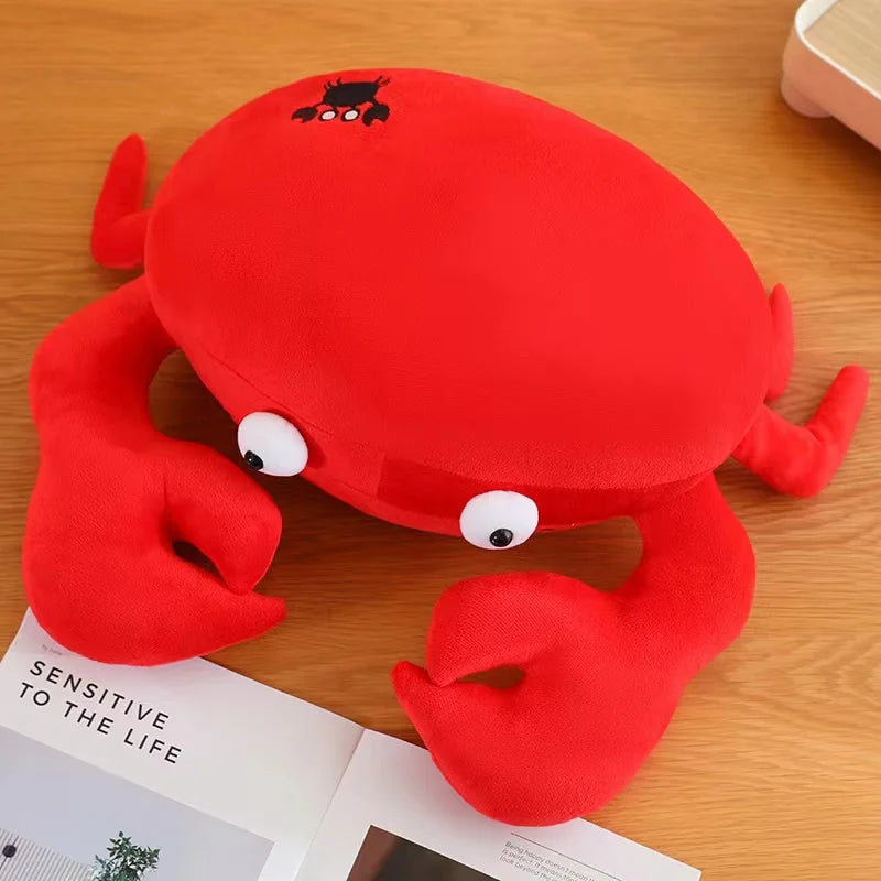 Red crab kawaii plush toy on a wooden surface with an open book underneath.
