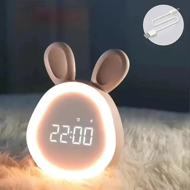 Cute rabbit-shaped kawaii digital clock with a cable icon in the corner on a soft surface.