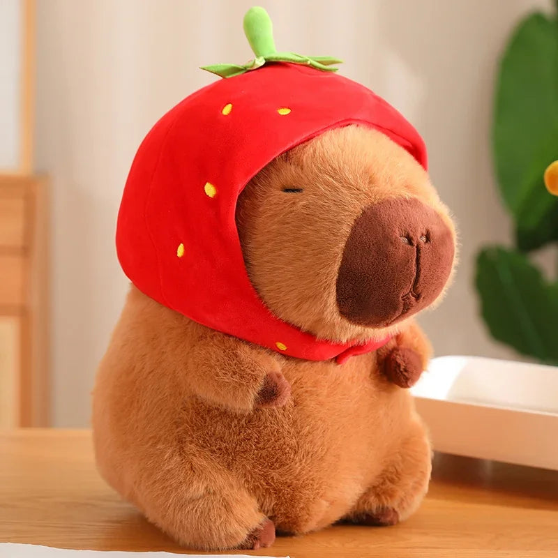 Kawaii plush toy resembling a bear wearing a red strawberry hat on a wooden surface.