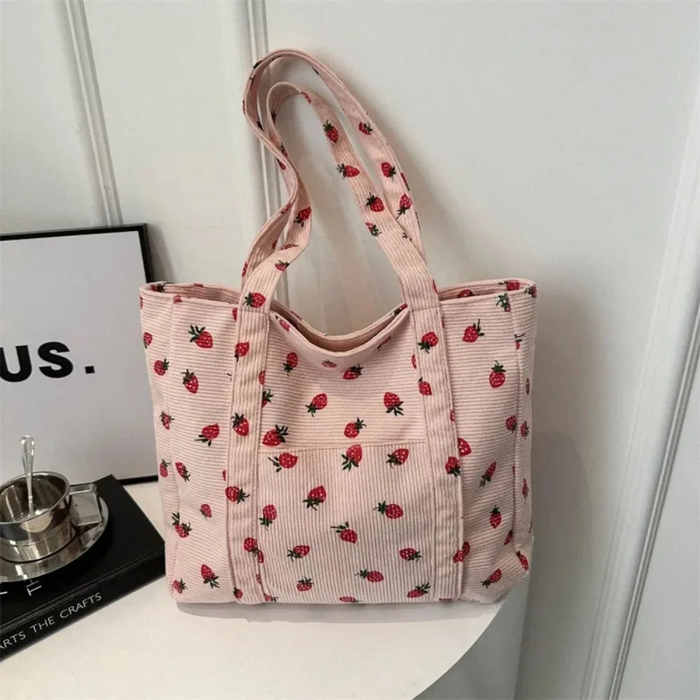 Pink tote bag with kawaii strawberry pattern on a white surface