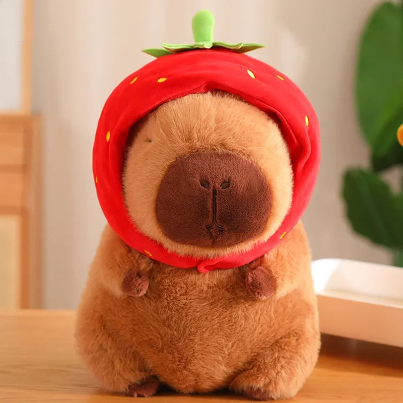 Kawaii plush toy resembling a bear wearing a strawberry hat on a wooden surface.