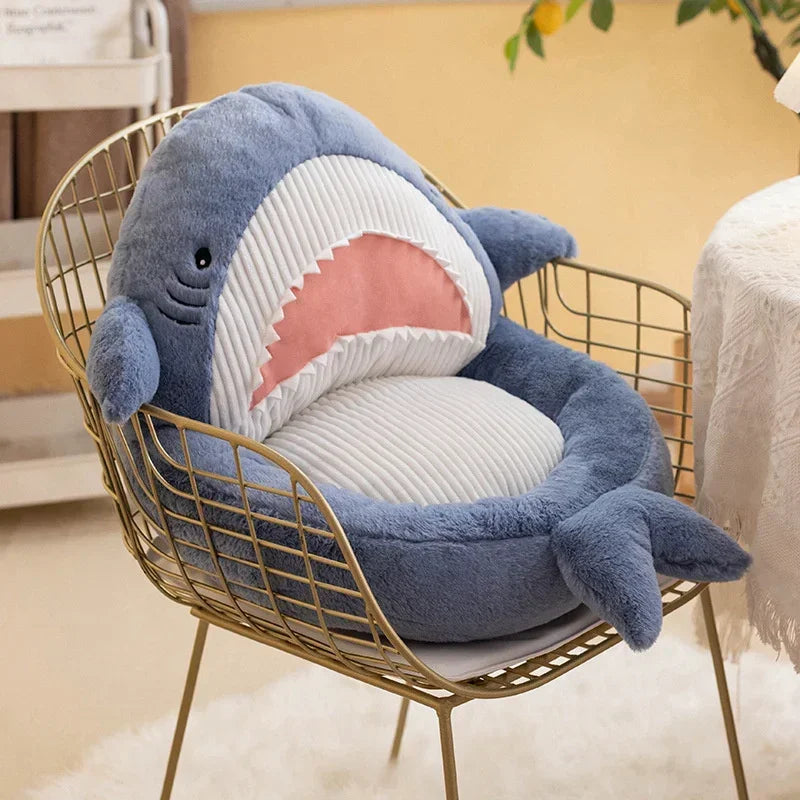 Shark-shaped kawaii cushion on a wire chair with a blurred indoor background