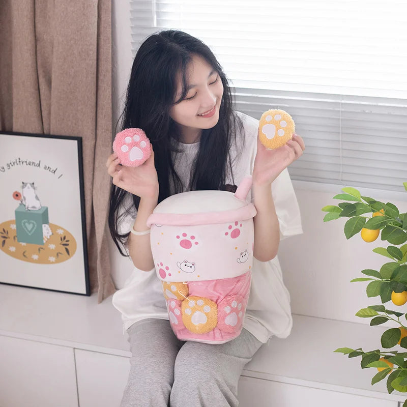 Woman holding a pink kawaii plush toy shaped like boba tea