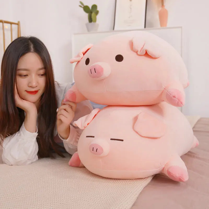 Woman holding a large pink kawaii pig plush toy in a cozy room.