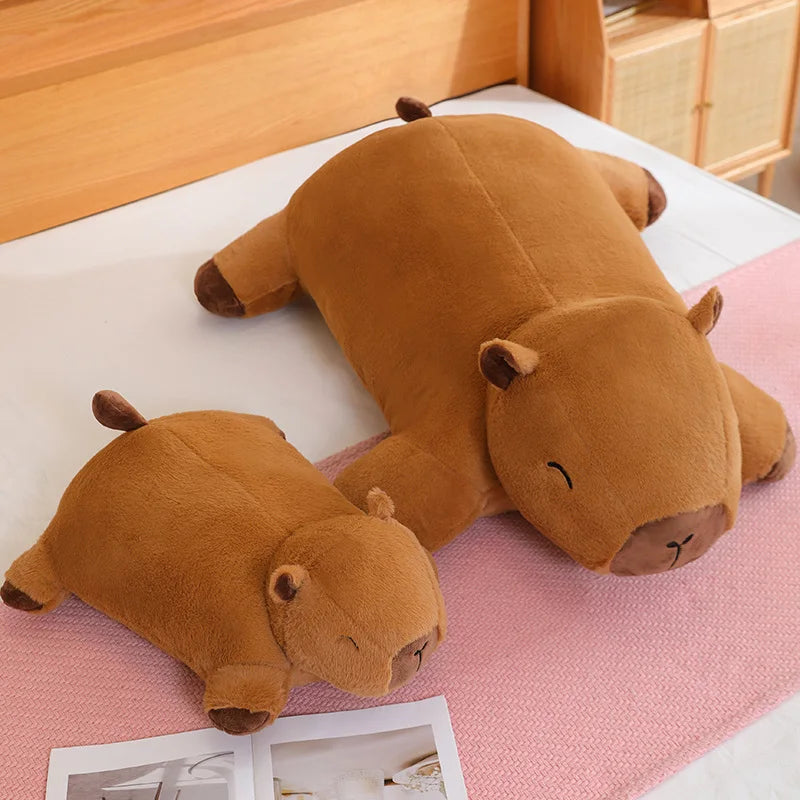 Two brown hippo-shaped kawaii cushions on a pink surface with a wooden background