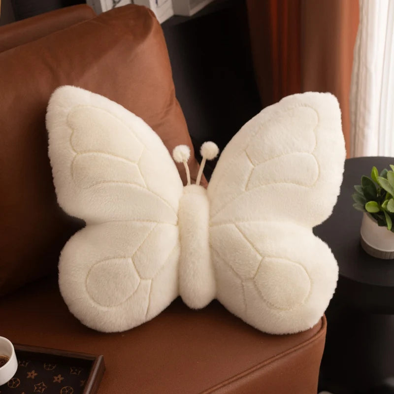 White butterfly-shaped kawaii pillow on a brown couch