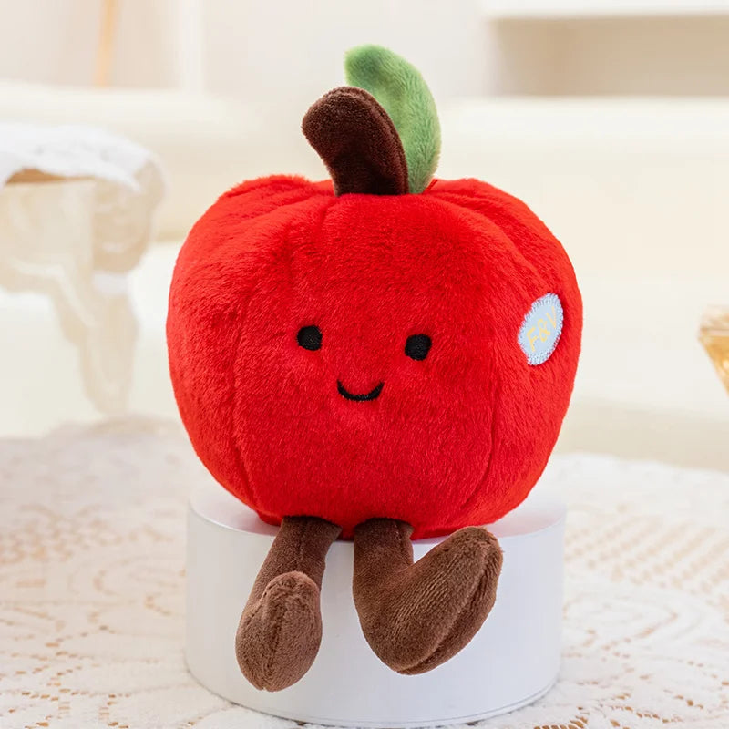 Plush kawaii toy shaped like a red apple with a smiling face on a white surface.
