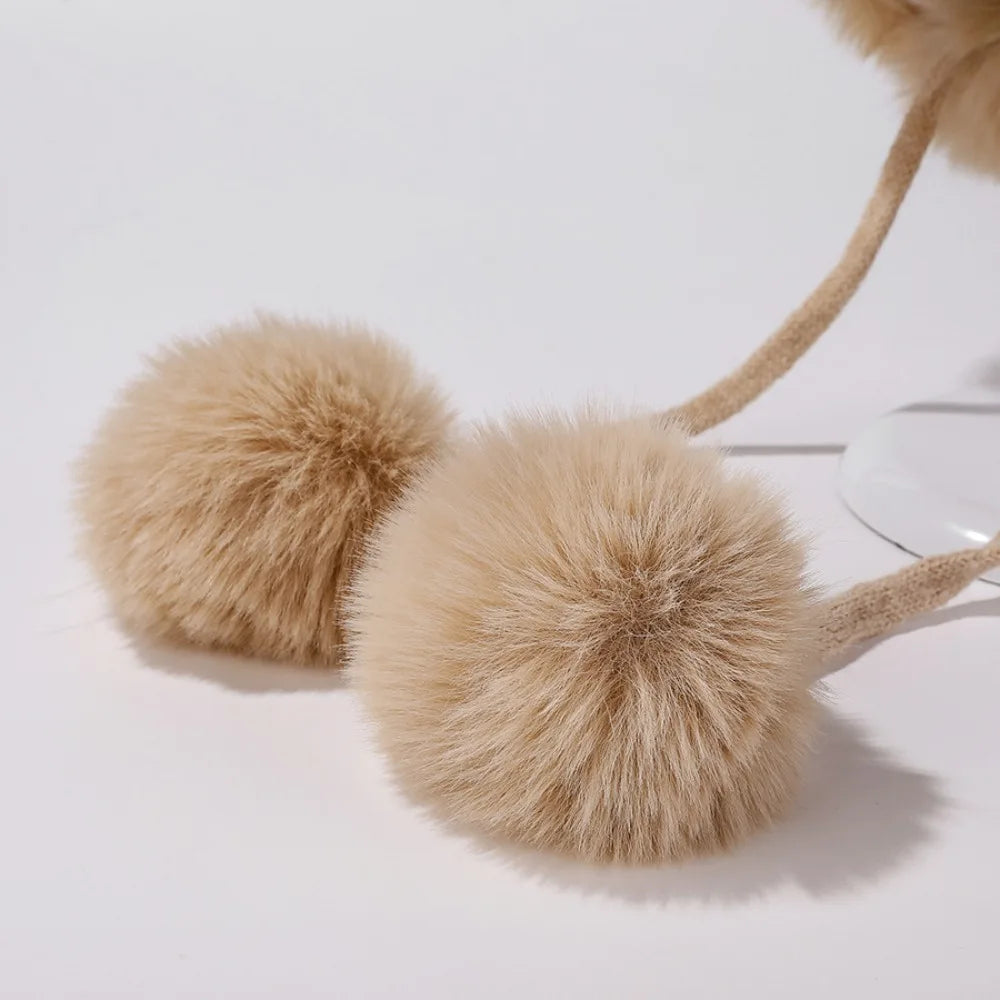 Pair of beige pom-pom Kawaii slippers on a light background