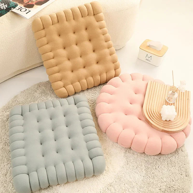 Three textured kawaii cushions in beige, gray, and pink on a carpeted floor.
