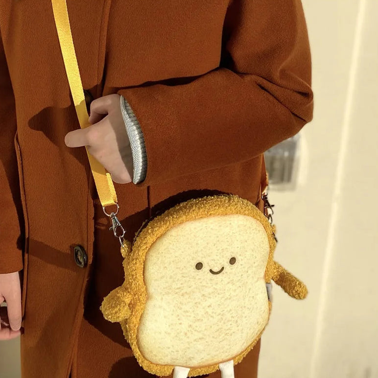 Person wearing a brown coat with a cute Kawaii bread-shaped bag on a blurred background