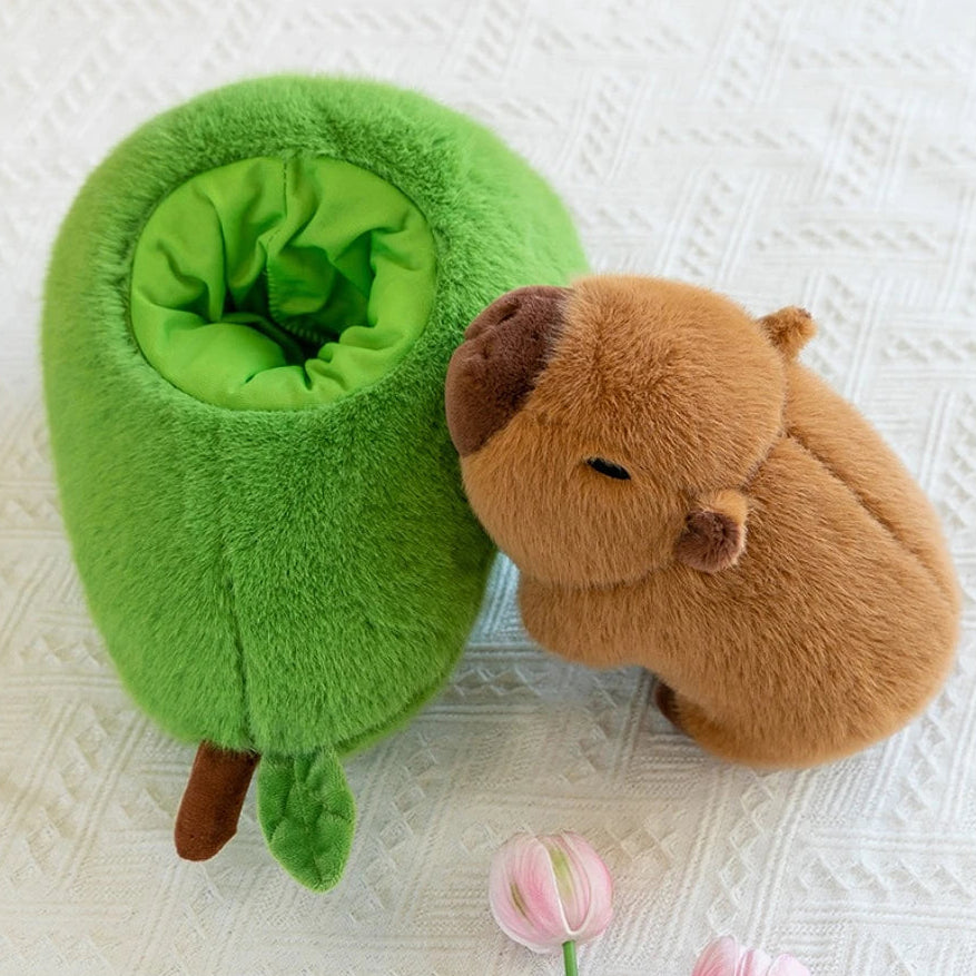 Green kawaii plush owl-shaped pet bed next to a brown plush animal on a textured white surface.