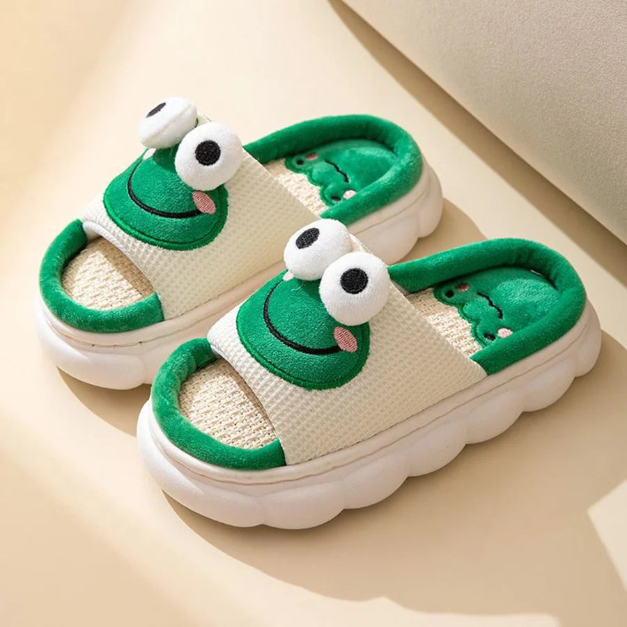 Pair of green and white children's kawaii sandals with frog design on a beige background