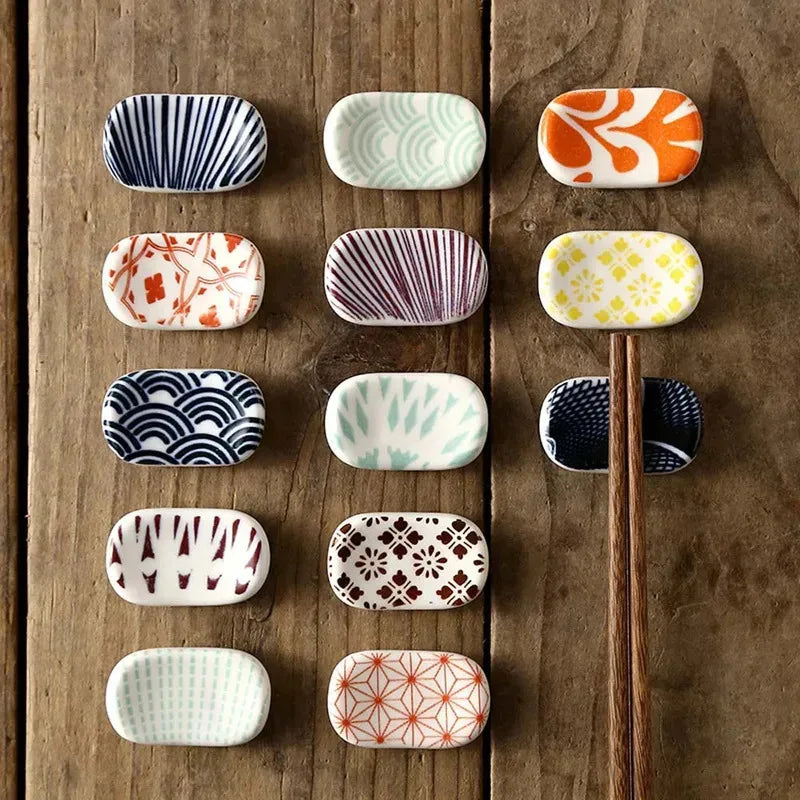 Set of small kawaii ceramic dishes with various patterns on a wooden surface
