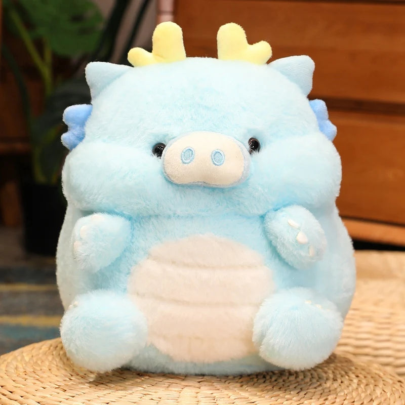 Kawaii plush toy resembling a blue creature with yellow horns on a woven surface.