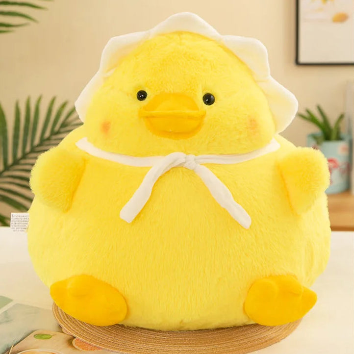 Yellow kawaii plush duck toy with a white hat on a light surface.