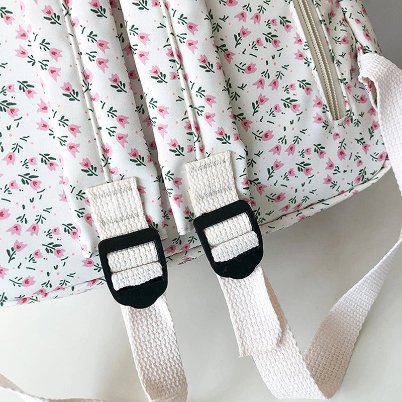Kawaii floral-patterned bag with white straps and black buckles on a light background