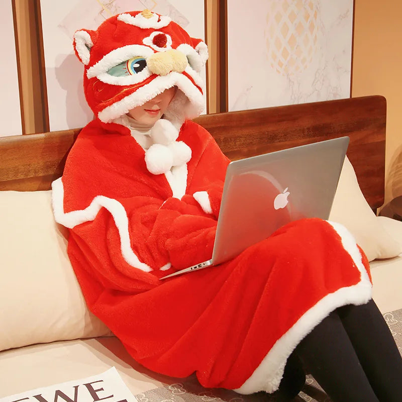 Person wearing a red and white kawaii animal-themed onesie using a laptop on a couch.