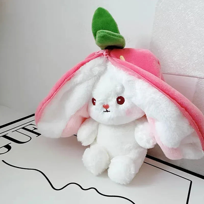 Plush kawaii toy rabbit inside a pink flower with green leaves on a white background