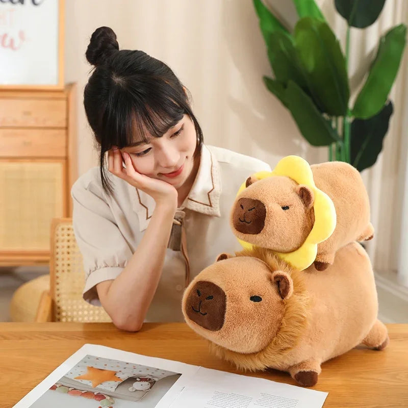 Woman sitting at a table with two brown kawaii plush toys resembling bears with yellow flowers on their heads.