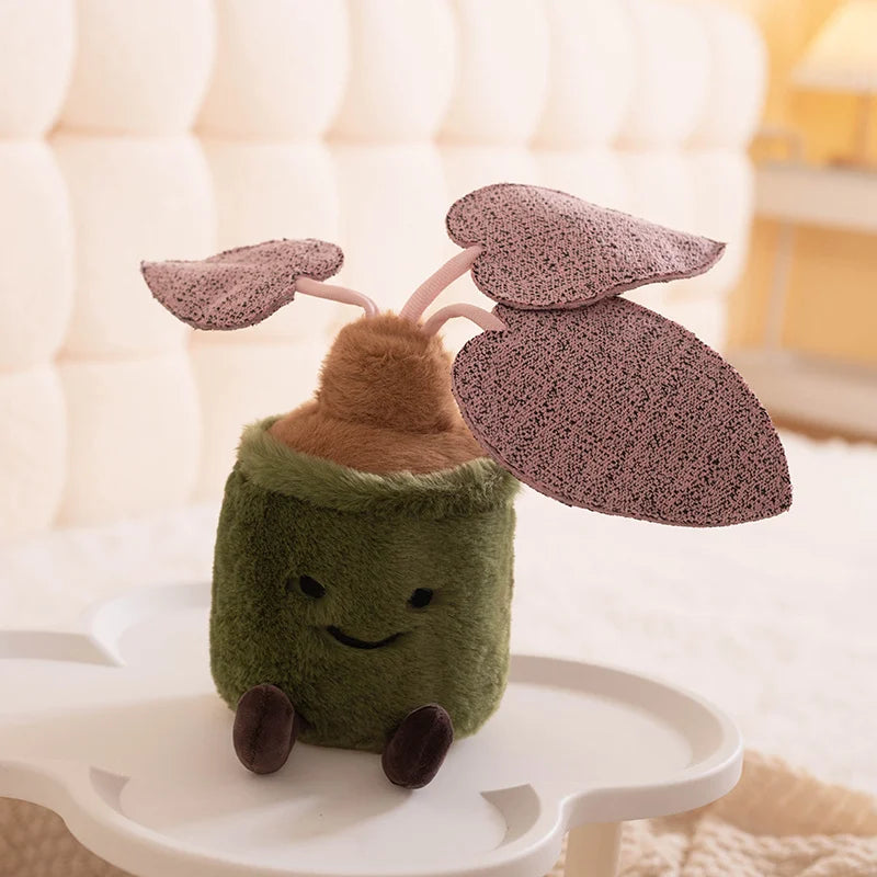 Plush kawaii toy resembling a plant with brown leaves on a white surface