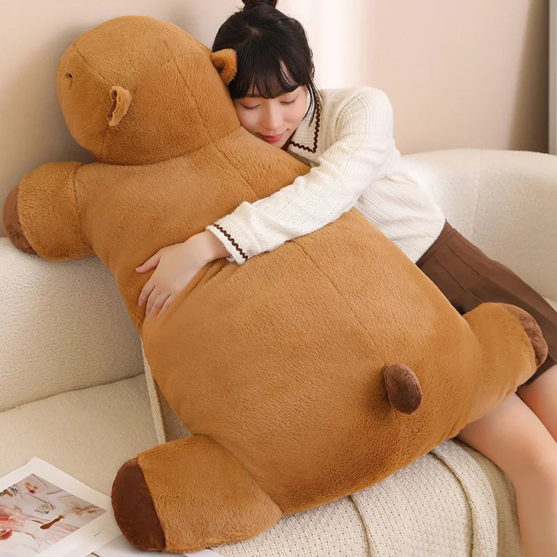 Person hugging a large brown kawaii teddy bear on a couch.
