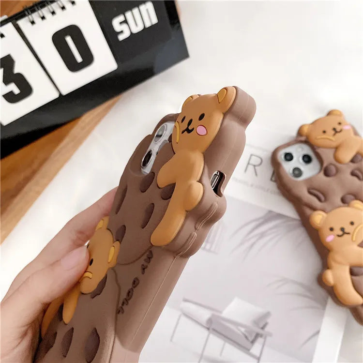 Phone case with kawaii bear design held by a hand, calendar in the background