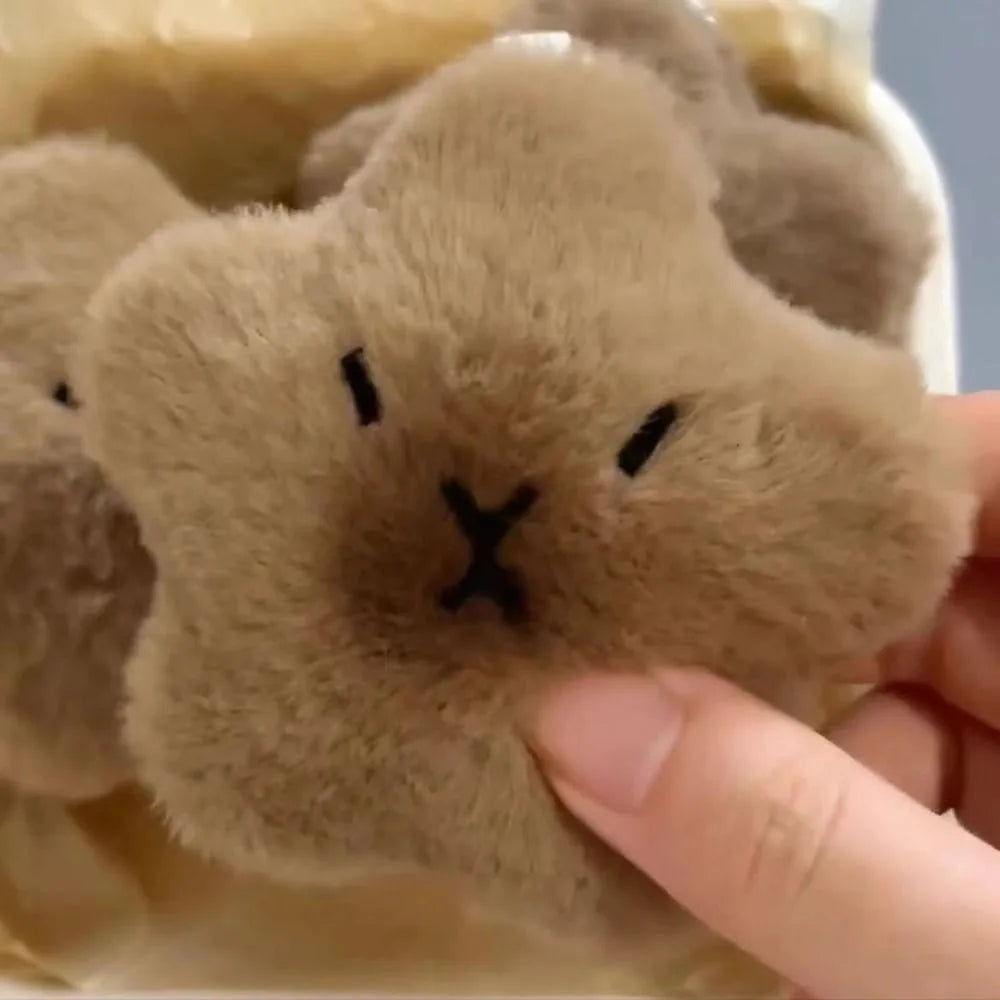 Close-up of a kawaii plush toy with a face, held by a hand.