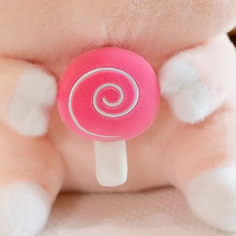 Kawaii-styled pink lollipop-shaped earbud on a finger