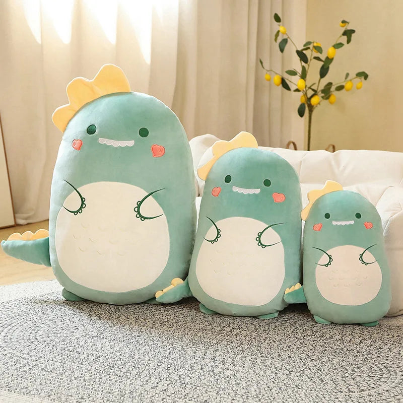 Three green kawaii plush toys with dinosaur designs on a carpeted floor.