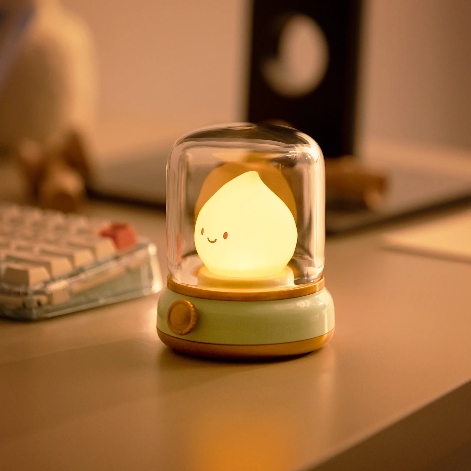 Cute kawaii night light with a smiling face in a glass dome on a desk.