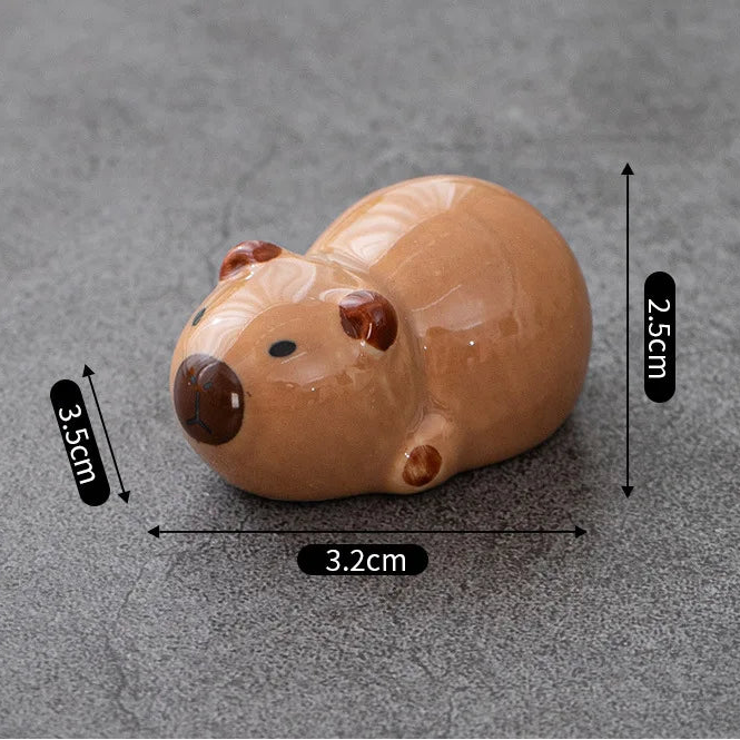 Small brown ceramic kawaii animal figurine with measurements on a gray background