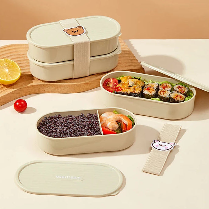 Set of kawaii bento boxes with food compartments on a wooden surface