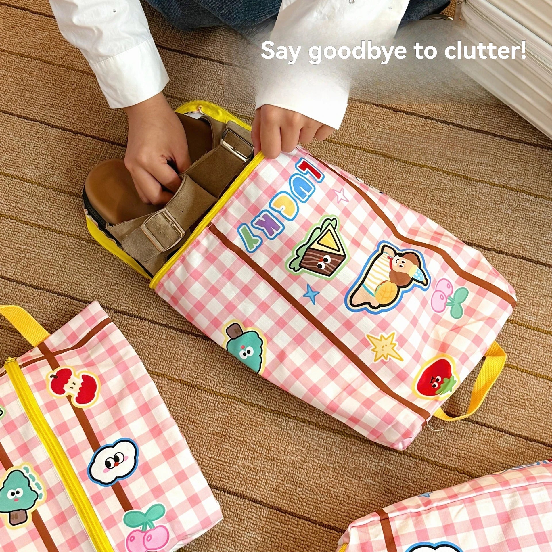 Children's pink checkered bags with Kawaii cartoon characters on a wooden floor.