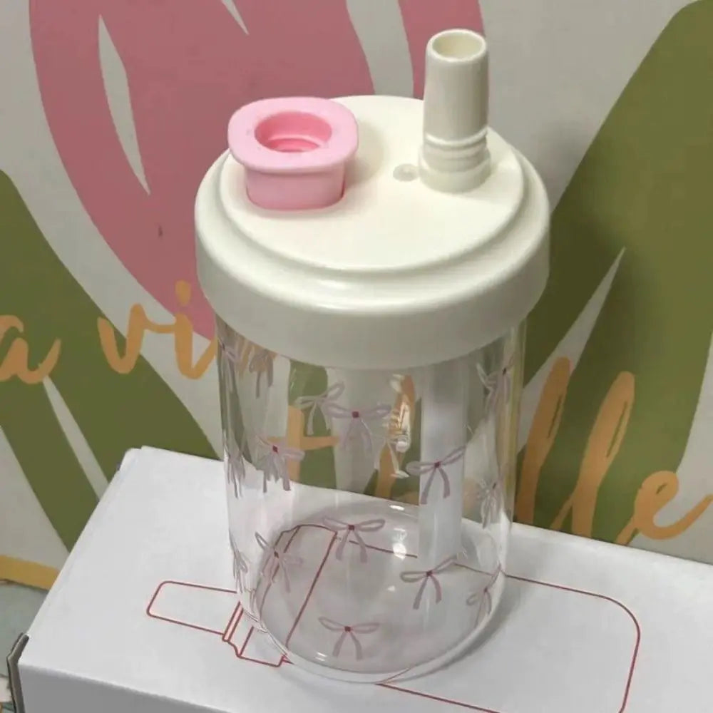 Clear drink Kawaii-style container with white lid and pink cap on a colorful background