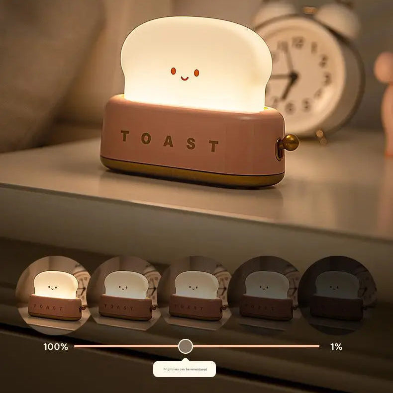 Light-up kawaii toaster toy with a smiley face on a shelf next to an alarm clock.