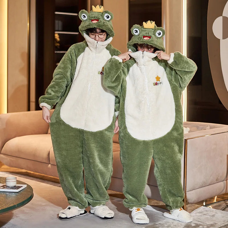 Two people wearing green kawaii frog-themed onesies in a room with a couch and table.