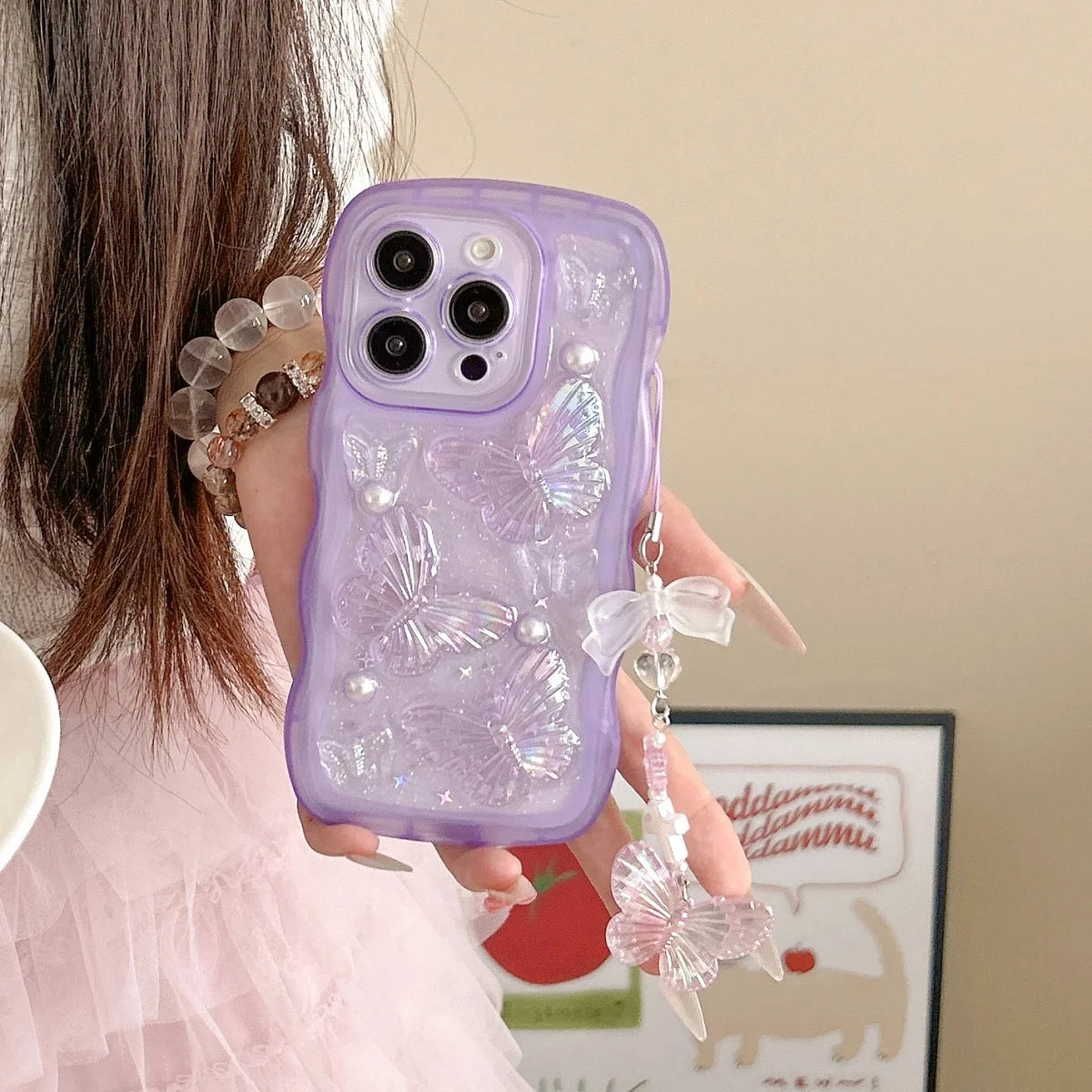 Person holding a purple kawaii phone case with decorative elements