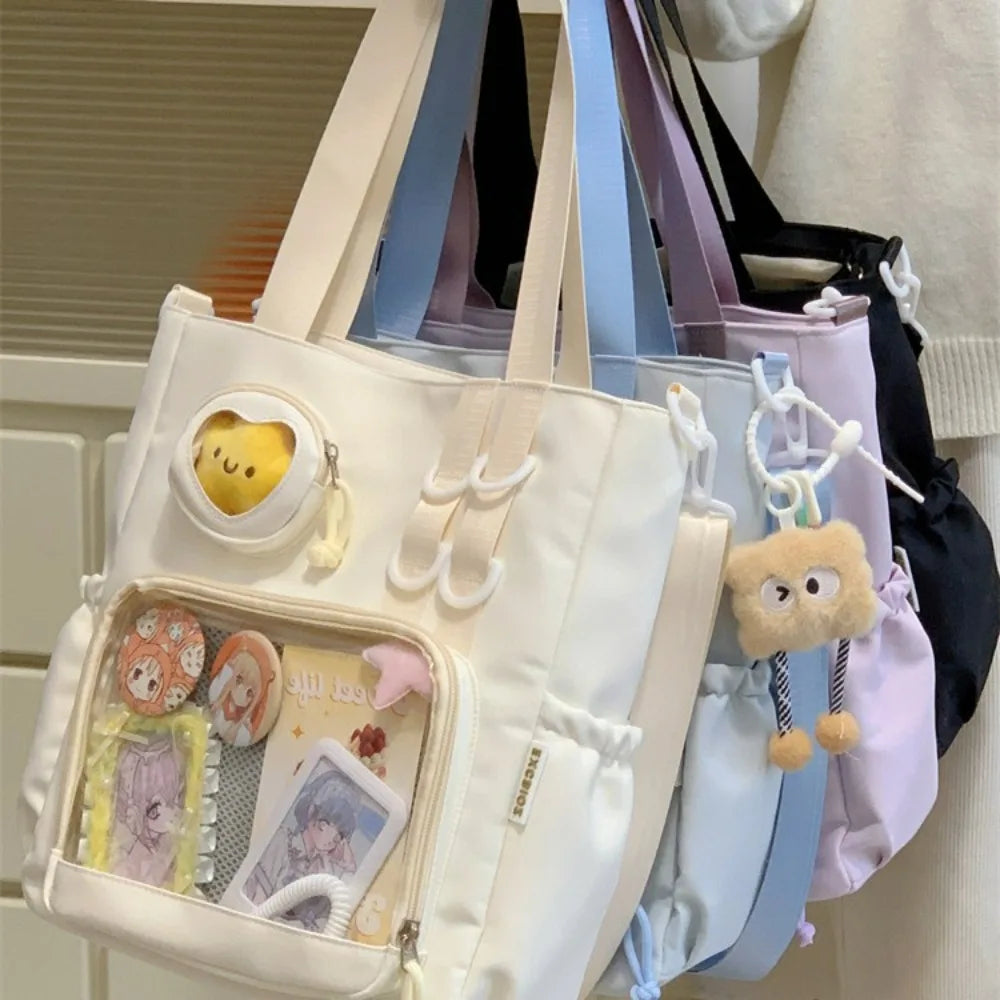 White tote bag with Kawaii plush toy keychain and compartments filled with items on a hanger.